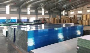 Kho hàng lớn lưu trữ các tấm polycarbonate phẳng được đóng kiện gọn gàng tại Tấm Polycarbonate – Vật Liệu Nhà Xanh